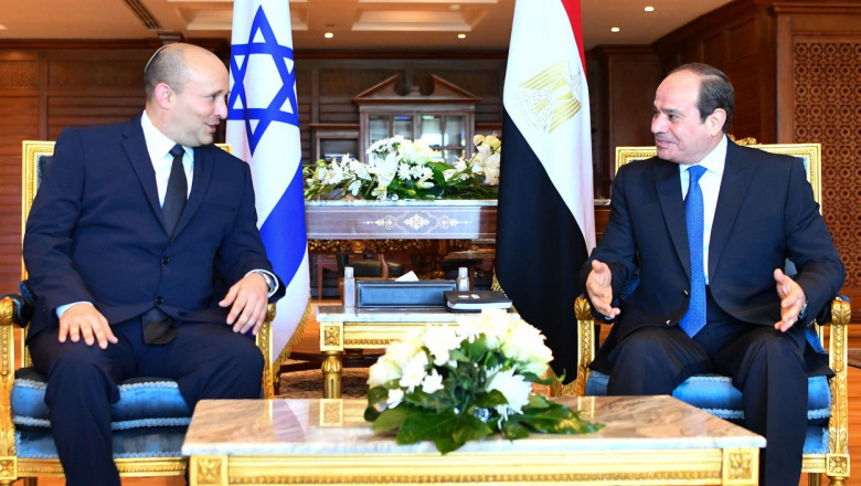Bennett și al-Sisis la masă, pe scaun, cu steagurile israelului și egiptului în spate la o întâlnire bilaterală în 2021