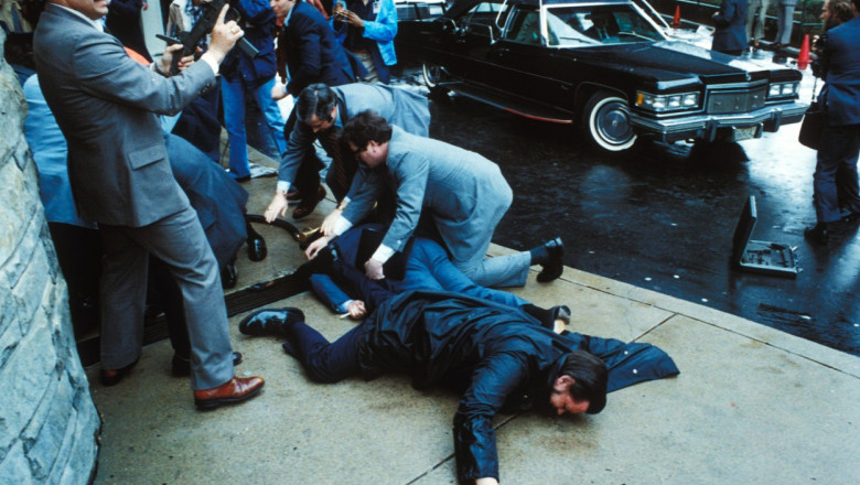 Polițiști îl pun la pământ pe John Hinckley după ce acesta l-a împușcat pe Ronald Reagan