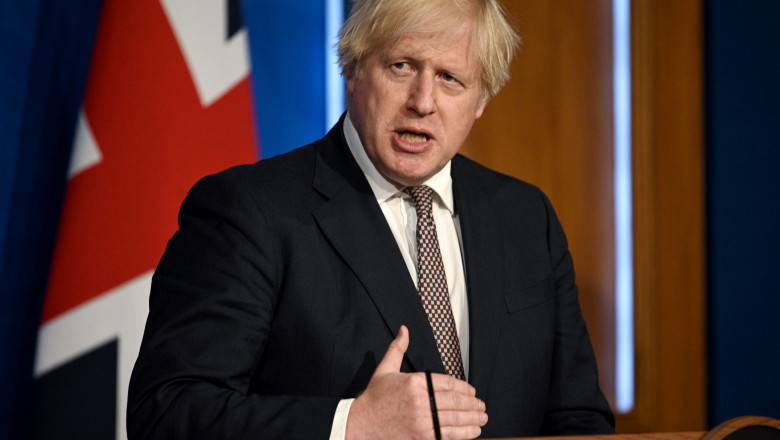 Boris Johnson la pupitru, in timpul declaratiilor, gesticuland cu mana