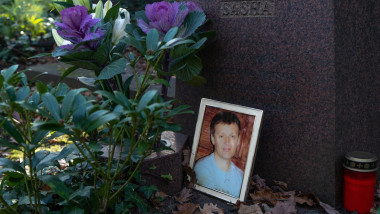 Flori și o fotografie înrămată pe un mormânt
