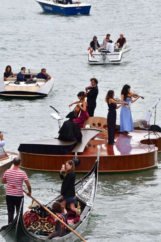 Parade in Venice on the Grand Canal of the Violin of Noah, the floating sculpture by Livio De Marchi, with craftsmen and a quartet of musicians on board