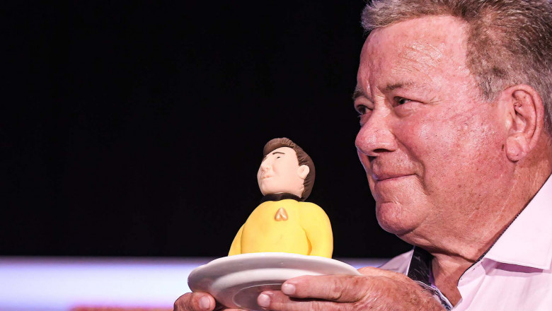 Actor William Shatner, best known for his portrayal of Captain James T. Kirk of the USS Enterprise in the Star Trek television series and movies, holds a portion of a birthday cake presented to him at a Q&amp