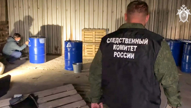 Employees of the Russian Investigative Committee are seen at a trading and purchasing facility in the city of Orsk where a storage facility and production site of counterfeit alcoholic beverages had been discovered
