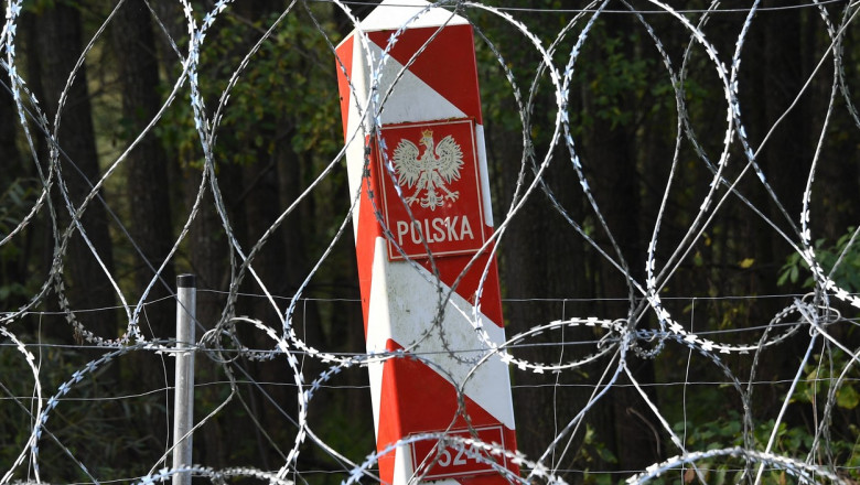 gard de sarma ghimpata in spatele caruia se vede un stalp pe care scrie polonia