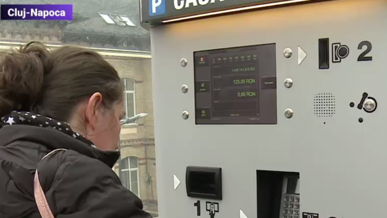 O femeie plătește parcarea la automat.