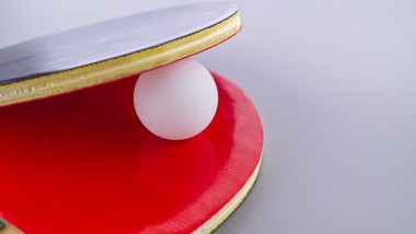 O minge de tenis de masă între două palete.