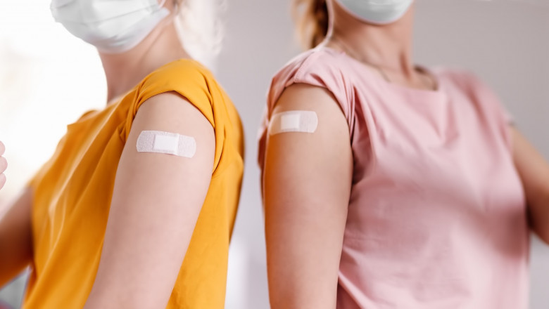 două fete vaccinate, cu plasture la locul injecției
