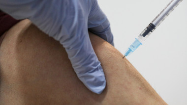 seringa cu vaccin introdusa in bratul unei persoane