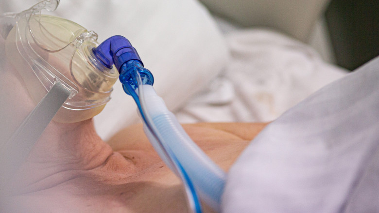 pacient covid in patul de spital cu tub si masca de oxigen
