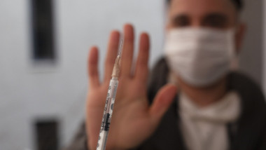om cu mana intinsa refuza vaccinul