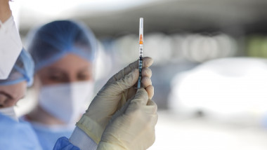 seringa cu vaccin tinuta in mana de un cadru medical