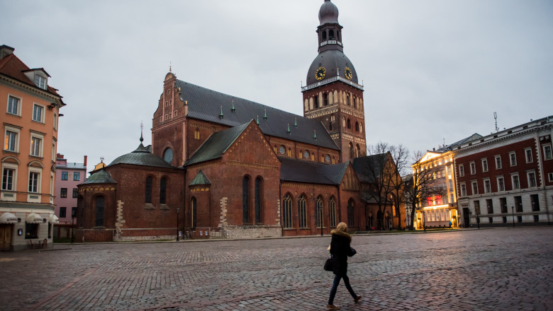 femeie singura in fata catedralei riga din letonia