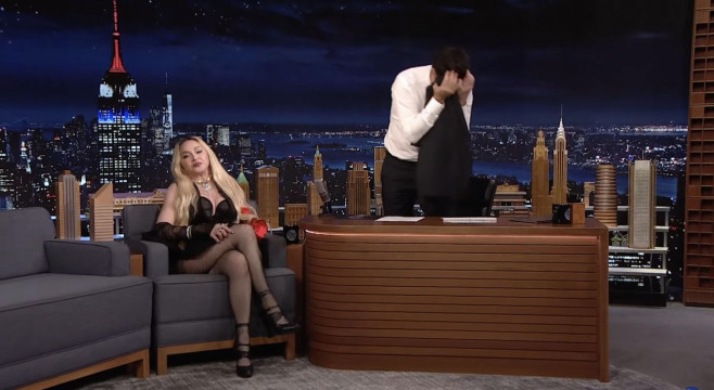 Madonna's interview with The Tonight Show's Jimmy Fallon goes completely off the rails as she climbs on his desk and then flashes the audience