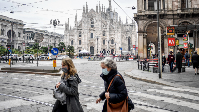 oameni cu masti in piata Duomo din Milano