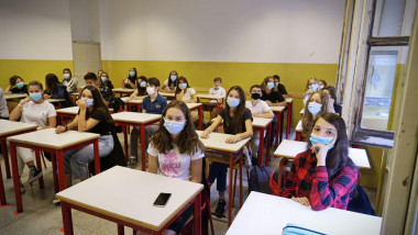 Elevi cu mască în sala de clasă.