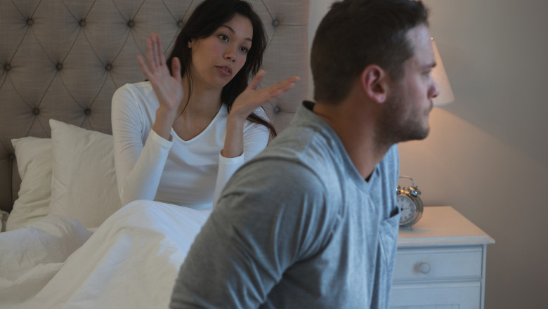 o femeie care stă în pat se cearta cu soțul său