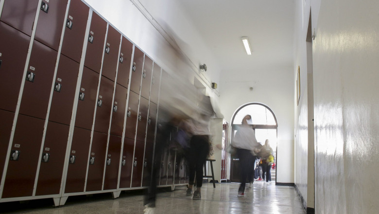 elevi alergand, in miscare, pe holul unei scoli