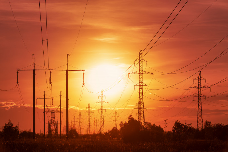 Energy crisis: power lines on a background of sunset in disturbing red tones