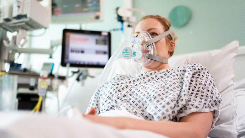 pacient cu masca de oxigen pe un pat de spital