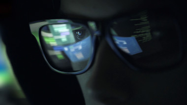 Nerd hacker with glasses in the dark