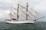 Sailors on board the Ecuadorian tall ship Guayas climb rigging to unfurl the sails.
