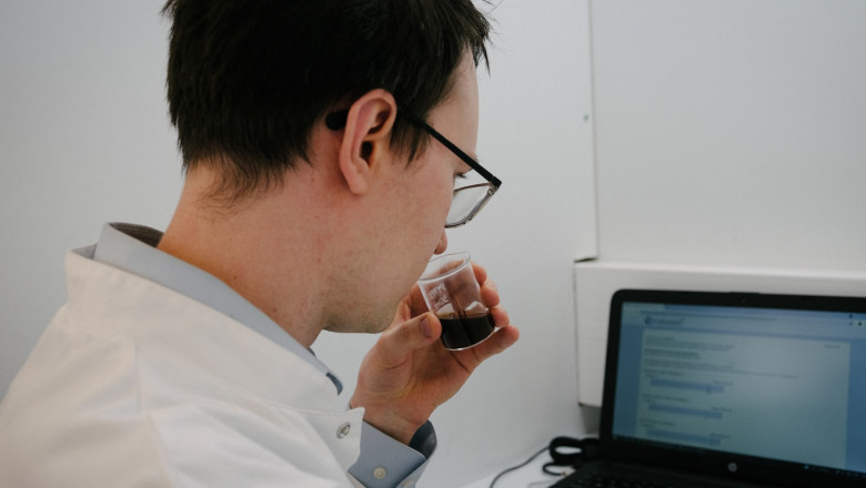 Unul dintre cercetători miroase și gustă cafeaua creată în laboratorul din Finlanda.