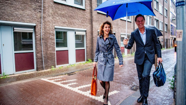 politicieni olandezi merg în ploaie cu umbrelă