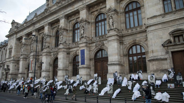oameni pe treptele curtii de apel bucuresti inveliti cu cearsafuri albe in memoria victimelor de la colectiv