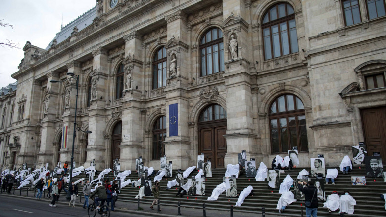 oameni pe treptele curtii de apel bucuresti inveliti cu cearsafuri albe in memoria victimelor de la colectiv
