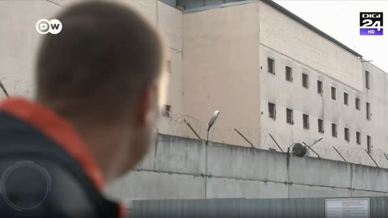 un barbat priveste către clădirea unei inchisori