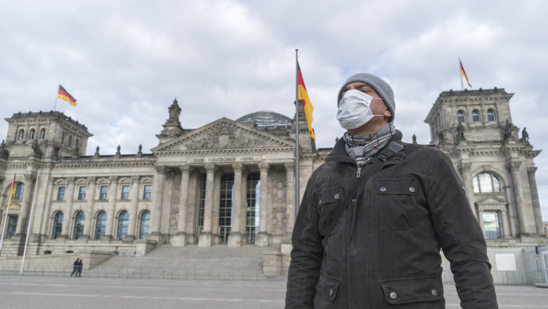 barbat cu masca in fata parlamentului din berlin