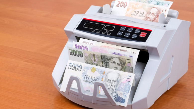 Bancnote cehești într-o mașină de numărat bani