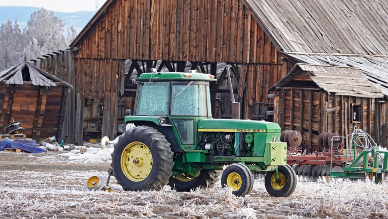 tractor verde vechi in fata hambarului cu promoroaca