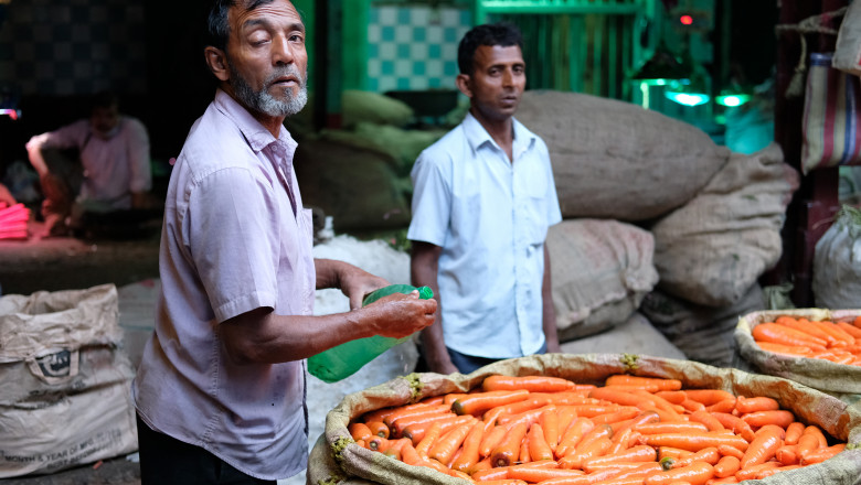 Doi fermieri indieni care vând morcovi în piața Koley, una dintre cele mai aglomerate piețe de legume din Kolkata.