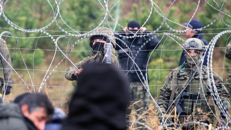 soldati polonezi dau gaze lacrimogene peste gardul de sarma ghimpata in migrantii din ba=elarus