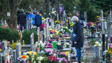 oameni printre morminte intr-un cimitir din polonia