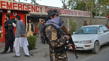 A Taliban fighter stands guard outside the entrance of a hospital