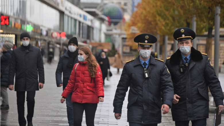Polițiști și oameni cu mască, pe stradă, în Moscova.