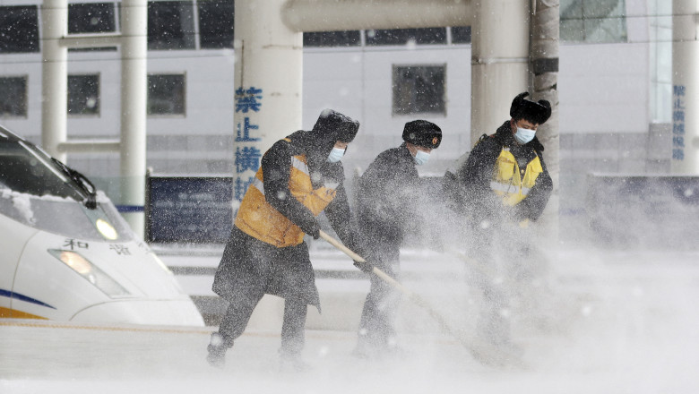 Mai mulți muncitori curățăzăpada de pe asfalt în nord-estul Chinei.
