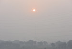 Fotografie cu cerul și Soarele ascuns în spatele fumului gros din New Delhi
