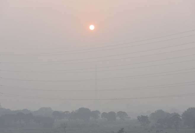 Fotografie cu cerul și Soarele ascuns în spatele fumului gros din New Delhi