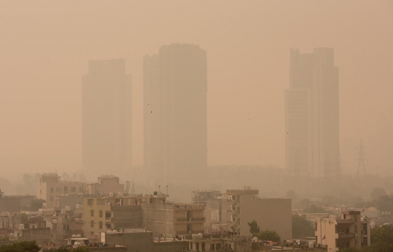 Orizontul capitalei indiene văzut prin fumul gros produs de poluare