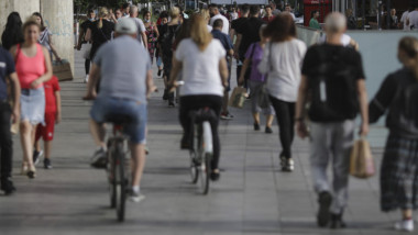 oameni pe strada cu biciclete si pe jos