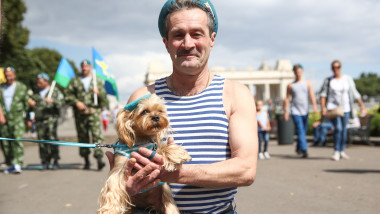 Un militar rus ține în brațe un câine, în timpul paradei de la Moscova.