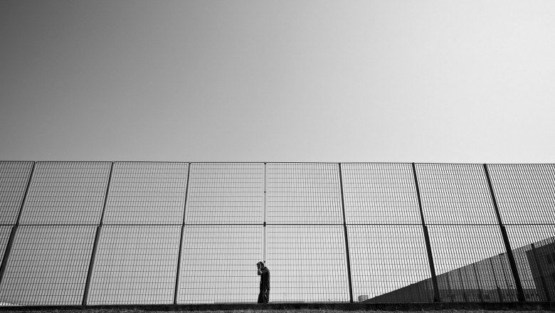 un barbat merge pe langa gardul unei inchisori din italia