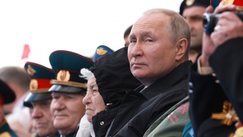 Vladimir Putin asistă la o paradă militară.
