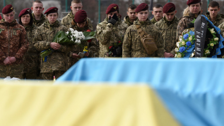 Militari ucraineni lângă sicriele camarazilor.
