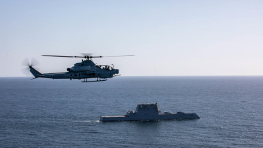 A U.S. Marine Corps AH-1Z Viper with Marine Light Attack Helicopter Squadron 169, Marine Aircraft Group 39, 3rd Marine Aircraft Wing (MAW), flies near the USS Michael Monsoor (DDG 1001), a Zumwalt-class destroyer, prior to conducting a flight deck landing