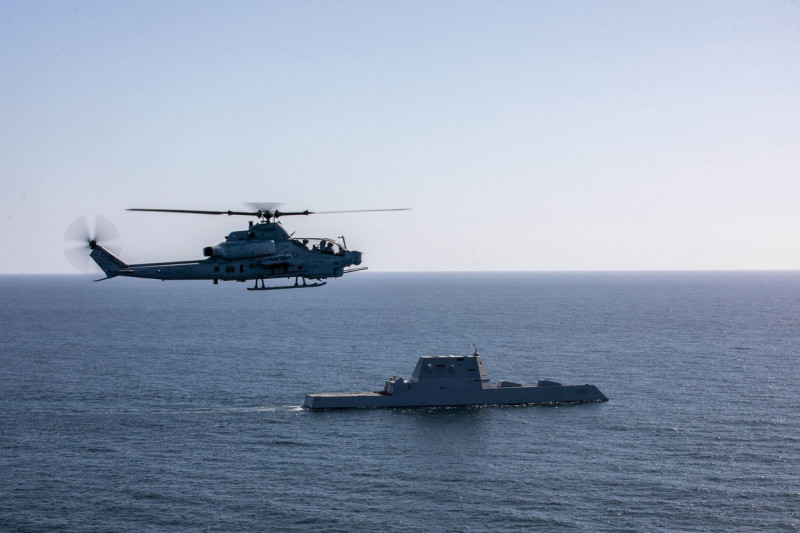 A U.S. Marine Corps AH-1Z Viper with Marine Light Attack Helicopter Squadron 169, Marine Aircraft Group 39, 3rd Marine Aircraft Wing (MAW), flies near the USS Michael Monsoor (DDG 1001), a Zumwalt-class destroyer, prior to conducting a flight deck landing