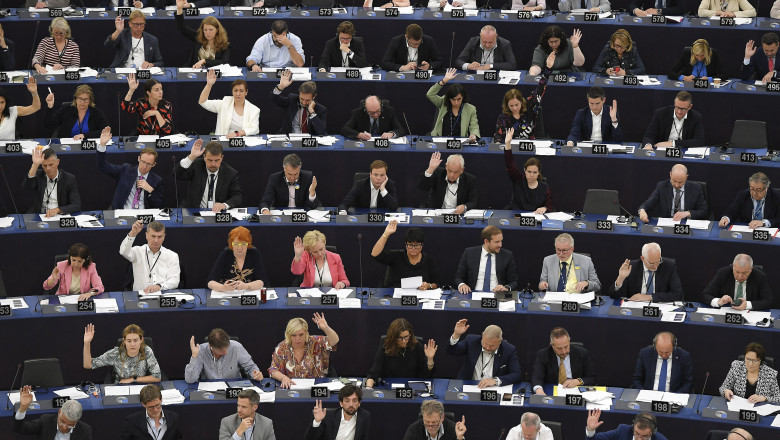 parlamentari europeni in plen, voteaza cu mainile ridicate